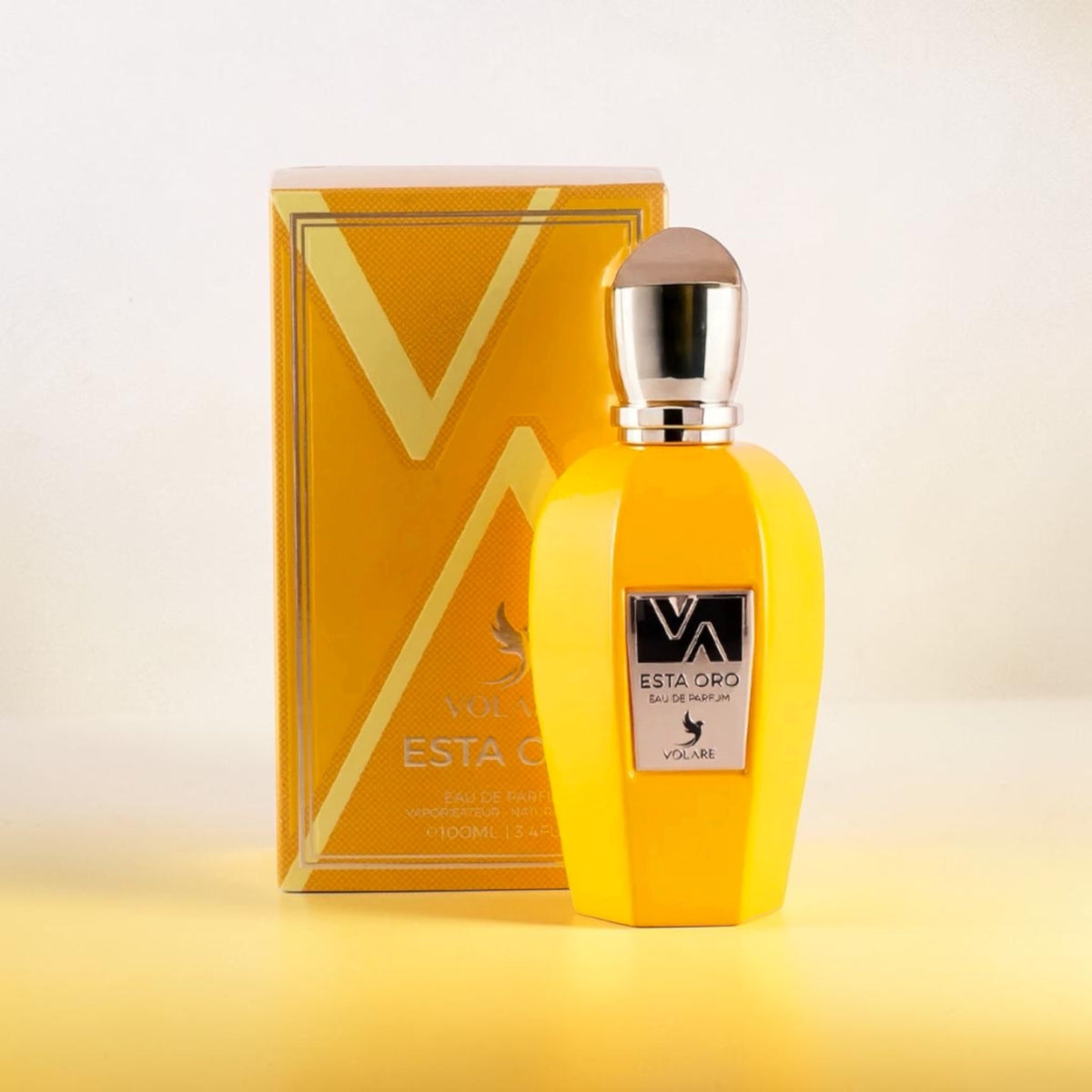 Esta Oro Volaré – Eau de Parfum Unisexe 100ml, flacon jaune avec bouchon argenté et coffret doré